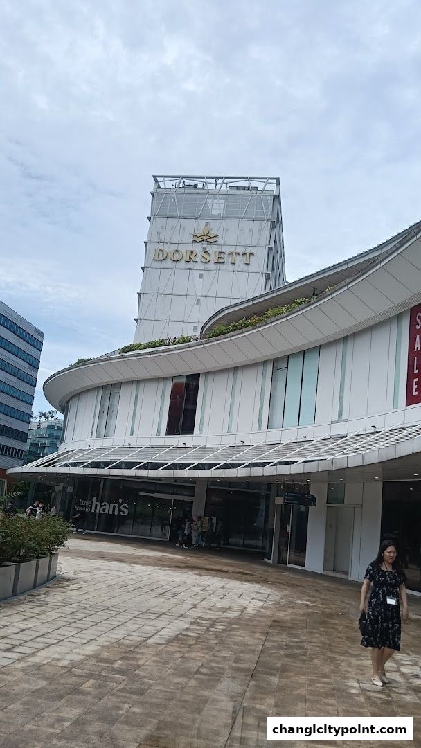 Exterior view of the Dorsett hotel and a shopping area with shops.