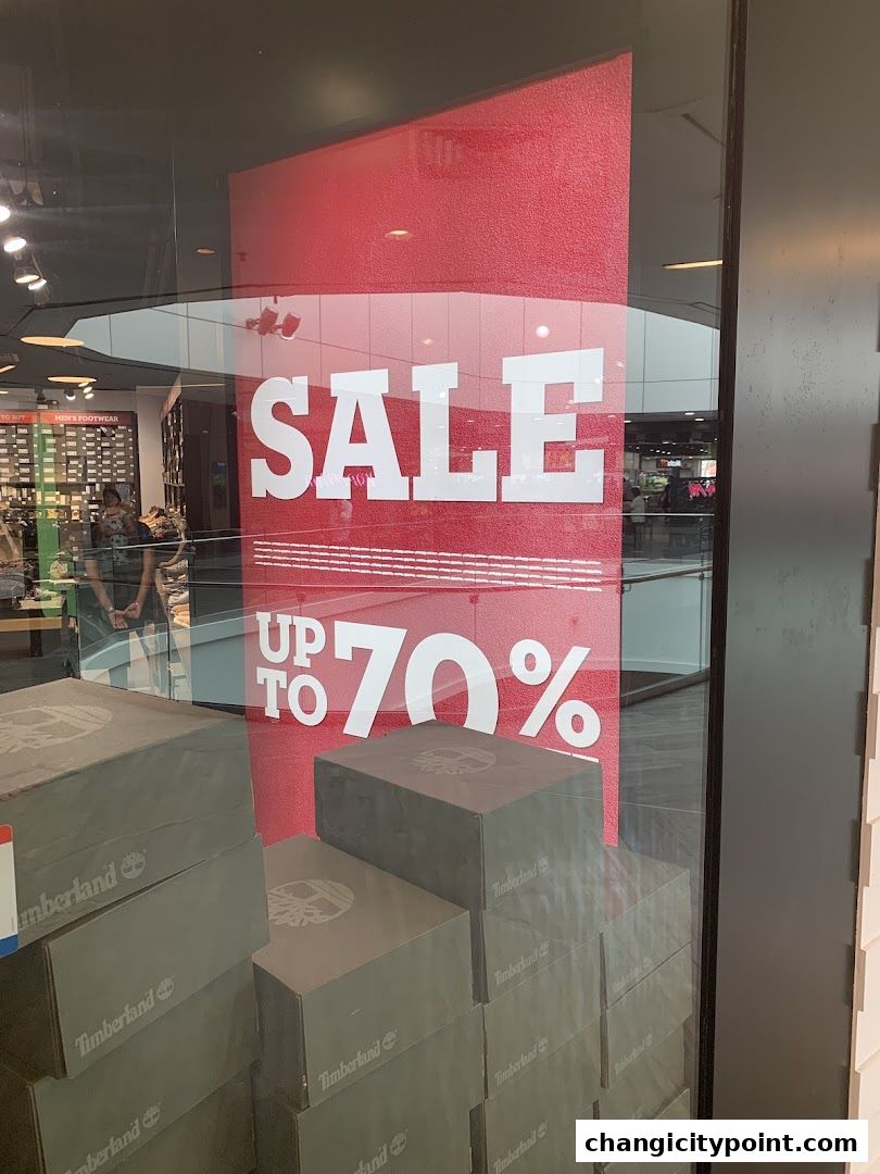 Timberland shop window displays a large 'SALE UP TO 70%' sign and stacked shoe boxes.