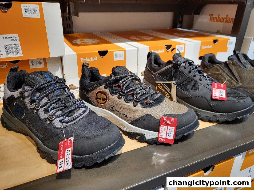 A display of Timberland hiking shoes and boots on shelves with branded boxes.