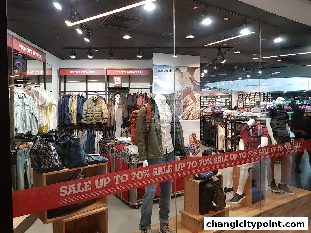 Timberland store window display featuring men's and women's apparel with a large sale banner.