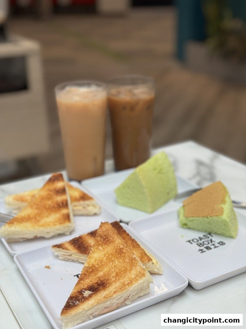 Toasted sandwiches and drinks served on white plates with the Toast Box logo.