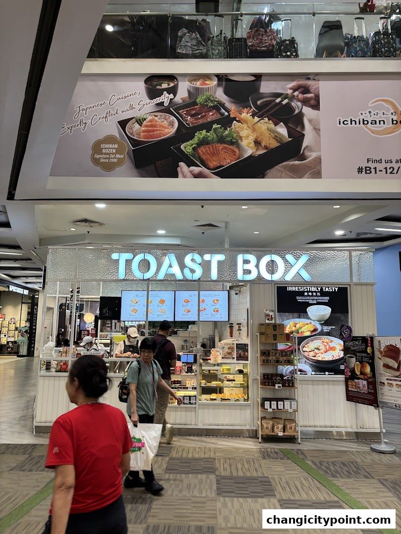 The exterior of a Toast Box shop with a display of food and menu boards.