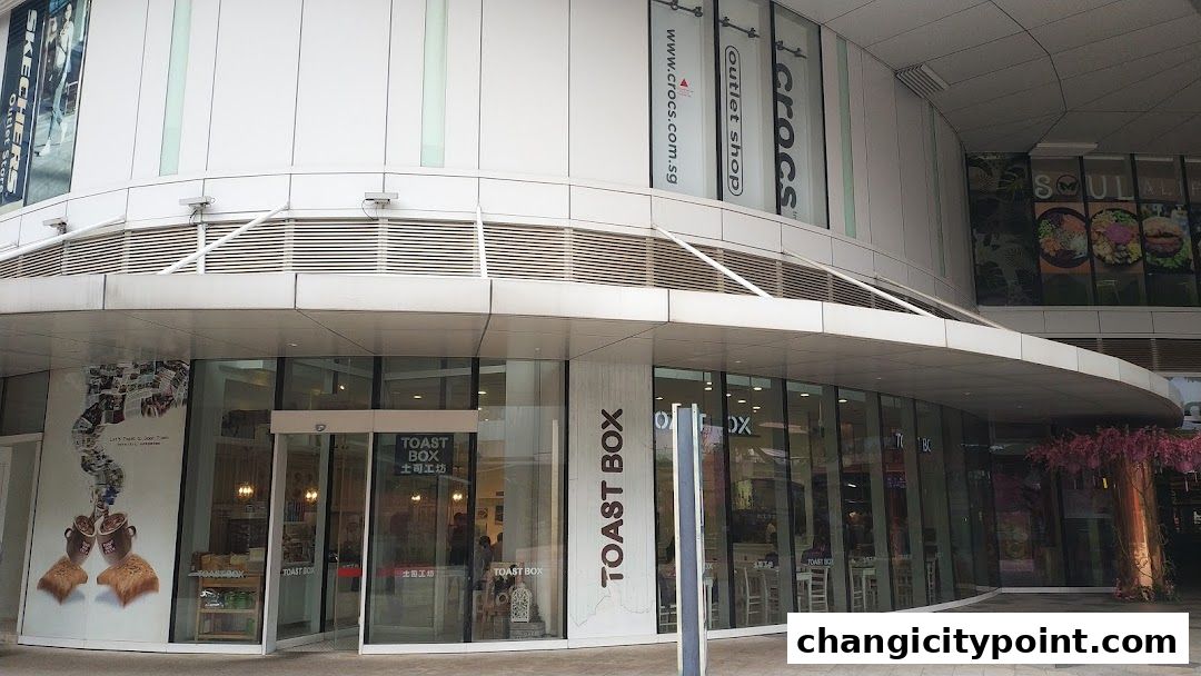Exterior view of the Toast Box cafe with large glass windows and signage.