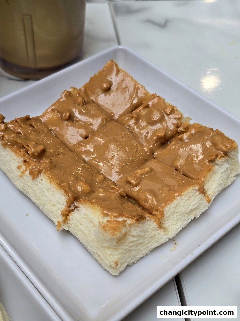 A close-up of thick peanut butter spread on toasted bread slices.