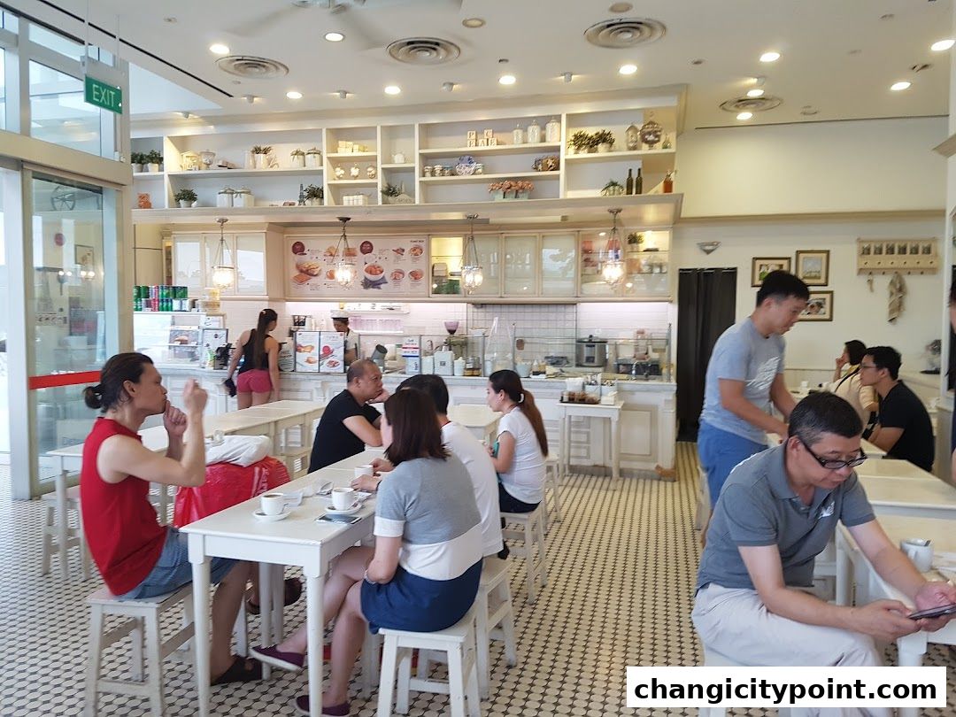 Interior of a busy Toast Box cafe with customers dining and staff serving.