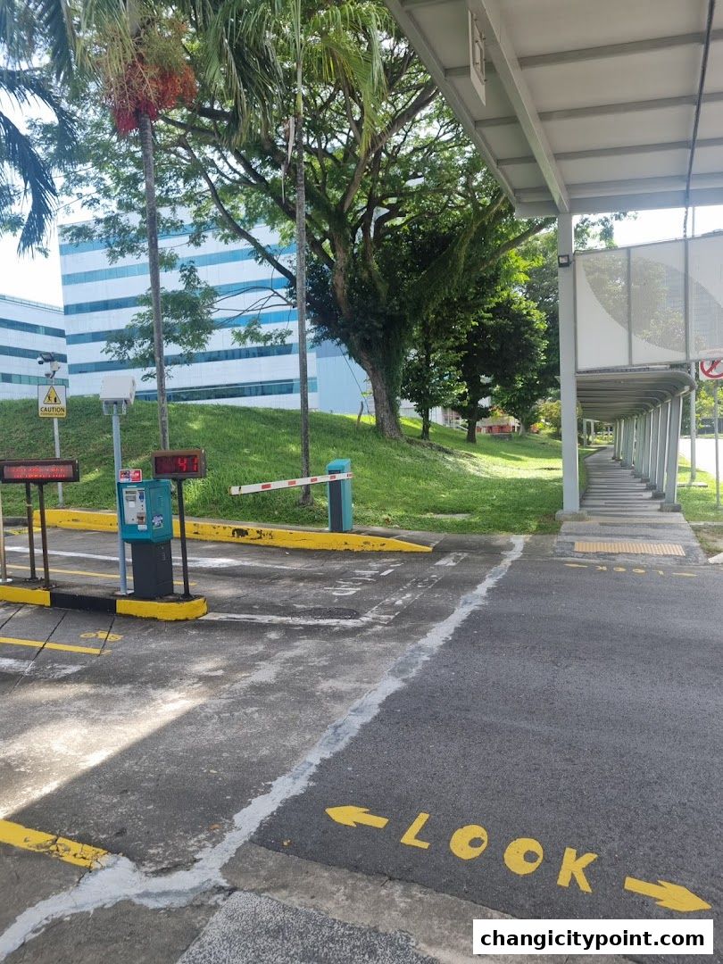 A view of a car park entrance with a boom gate and signage.