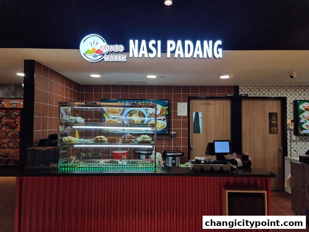 Tombo Warek Nasi Padang shop front with a display of food and a counter.