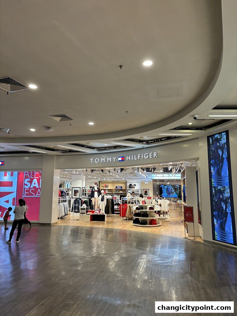 Tommy Hilfiger outlet store entrance with clothing displays and sale signage.