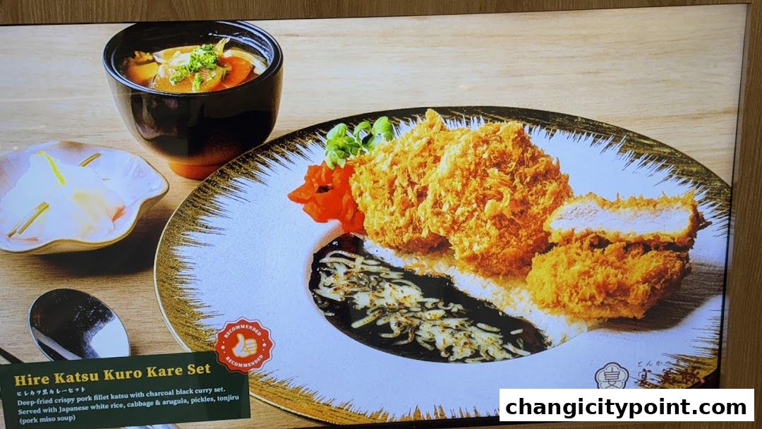 A delicious set meal featuring deep-fried pork katsu with black curry and rice.