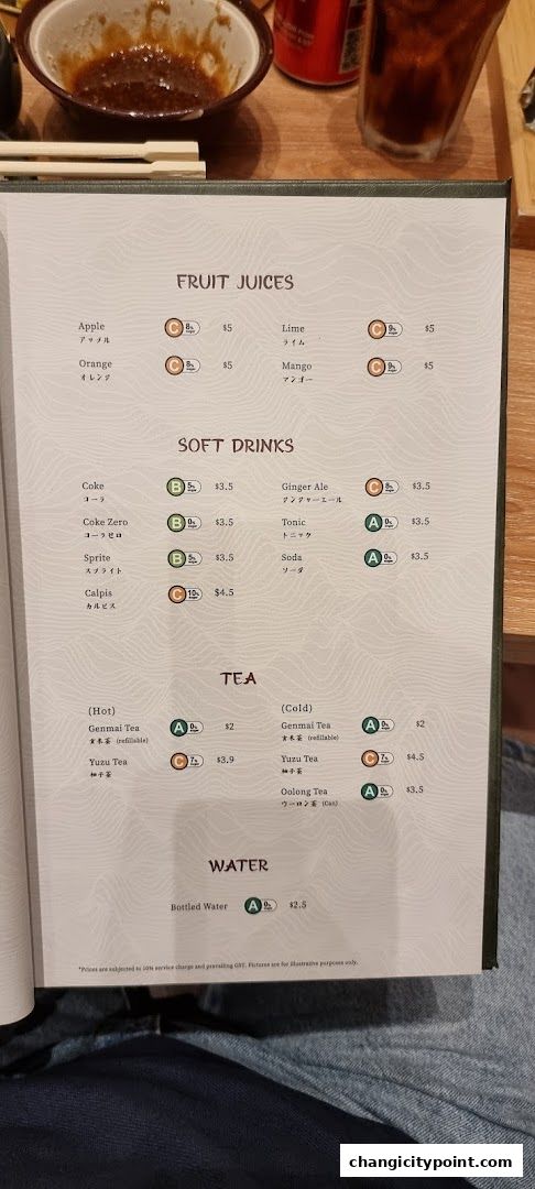 A menu page displaying fruit juices, soft drinks, tea, and water options with prices.