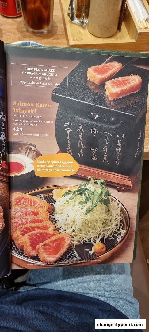 A menu item featuring Salmon Katsu Ishiyaki served with a hot stone grill and free flow cabbage.