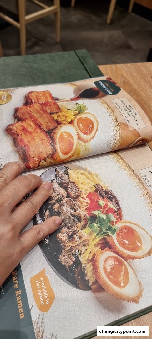 A close-up of a menu featuring two ramen dishes with pork and eggs.