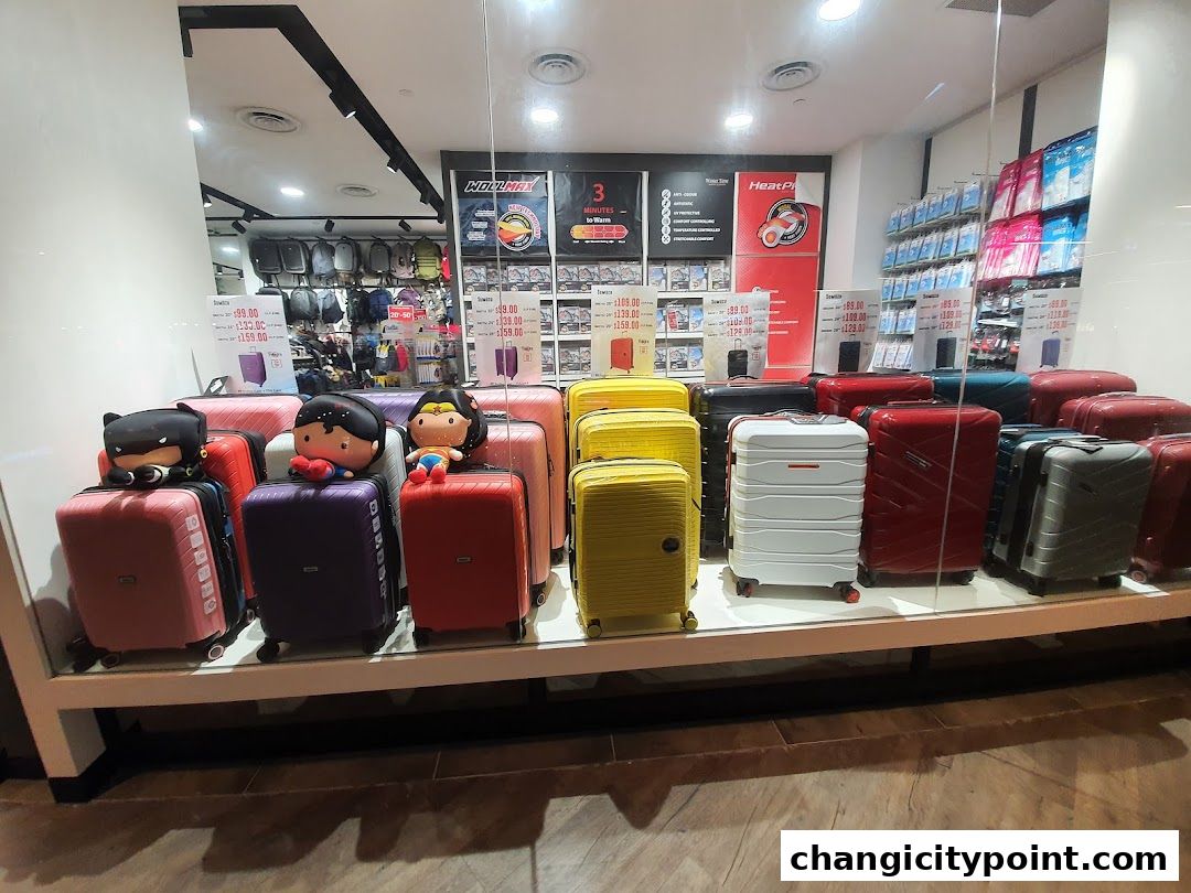 A display of colorful luggage and travel accessories in a shop window.