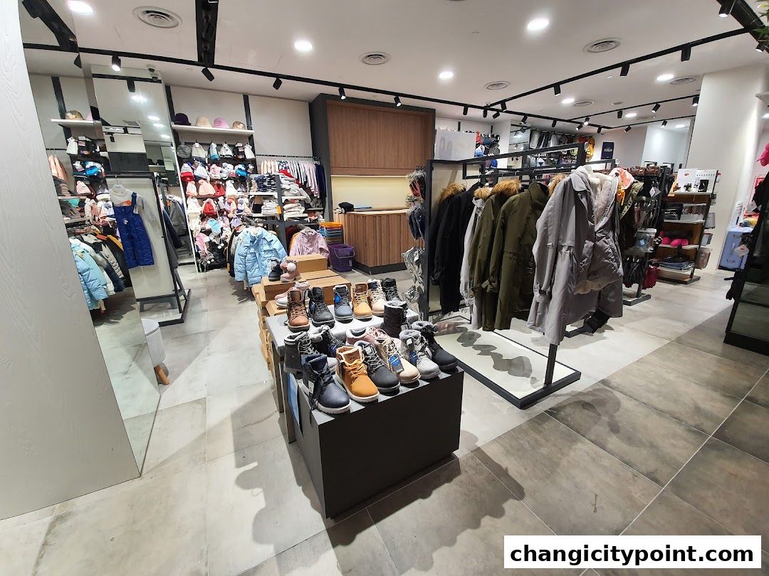 Interior view of a clothing store displaying jackets, shoes, and children's apparel.