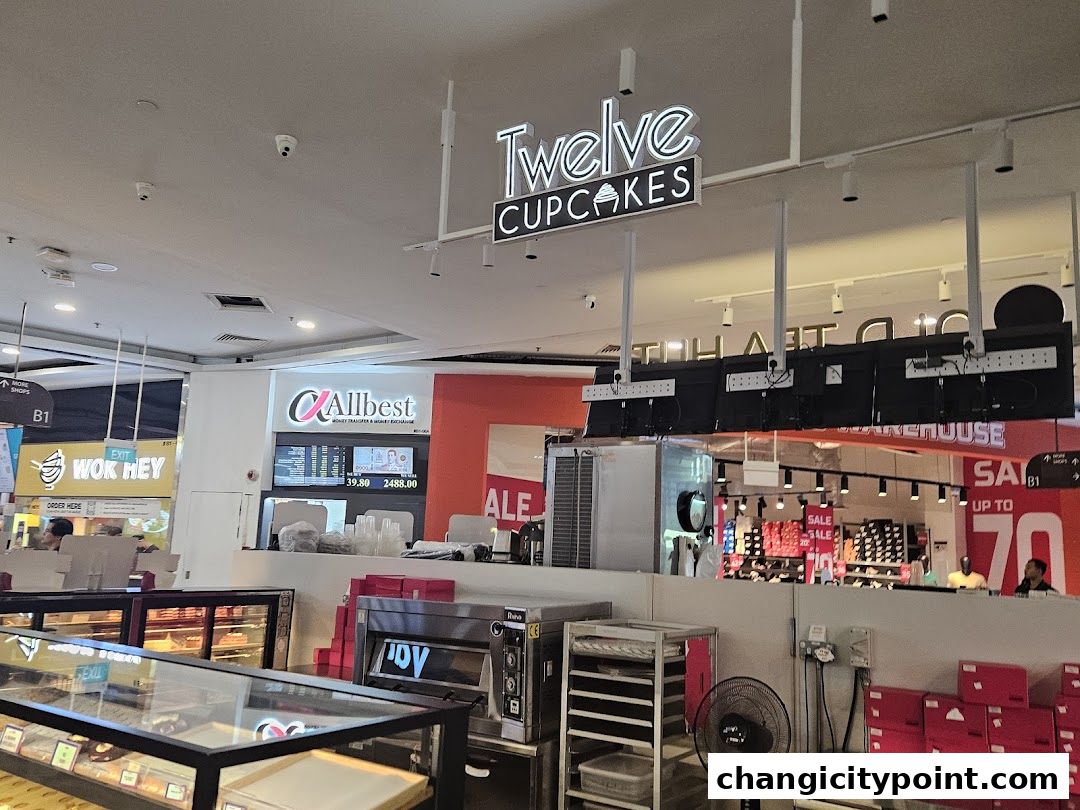 The interior of a shopping mall with a Twelve Cupcakes shop visible.