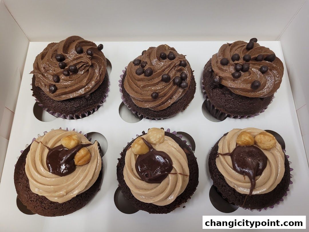 A box of six delicious chocolate cupcakes with various toppings.