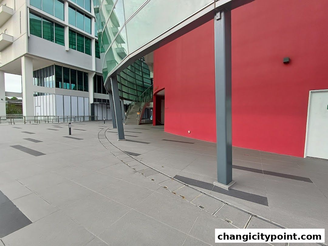 Exterior view of UE BizHub East building with modern architecture and red wall.