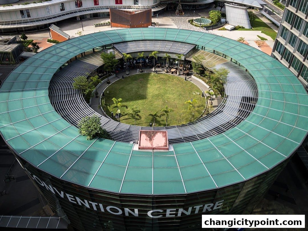 Aerial view of a circular convention center with a green roof and central courtyard.