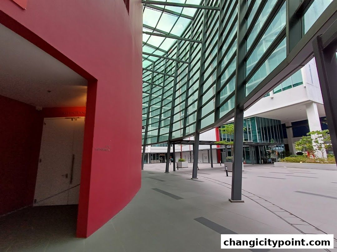 Modern architectural entrance with red wall and glass facade.