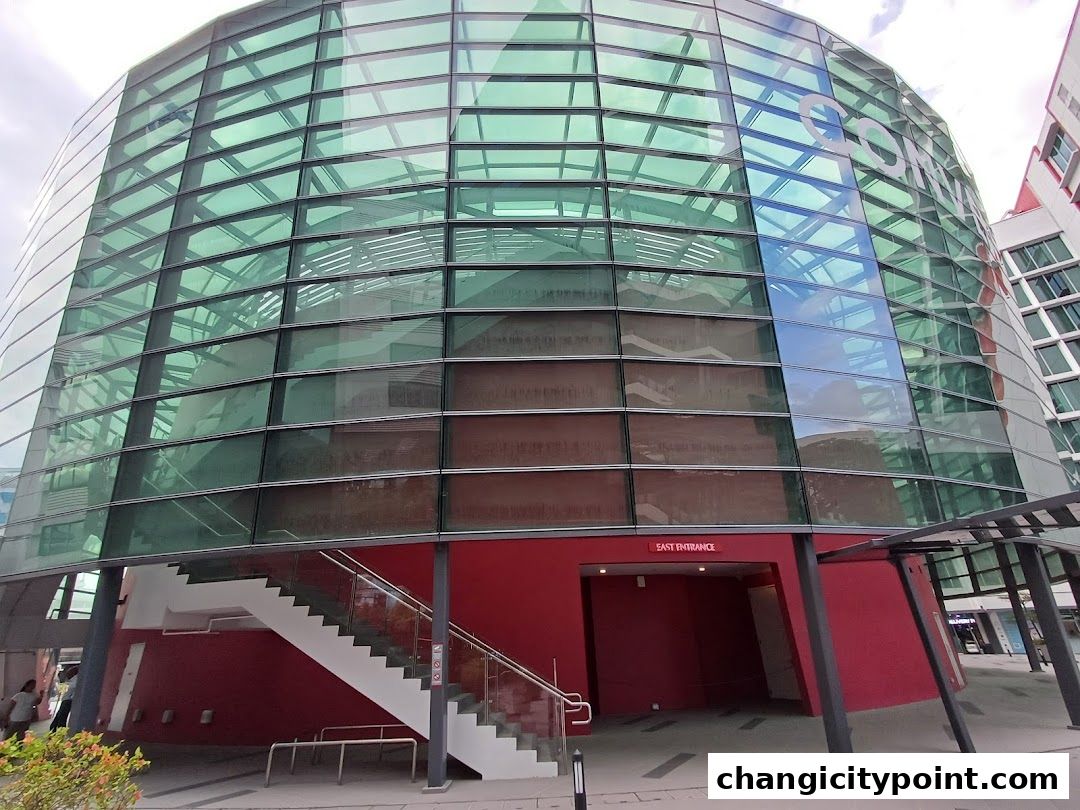 The East Entrance of UE BizHub East, a modern building with a glass facade and red accents.