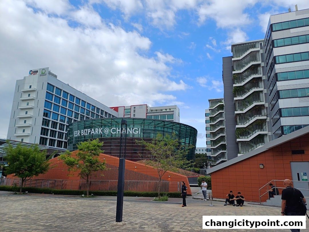 Modern office buildings with unique architectural designs under a cloudy sky.