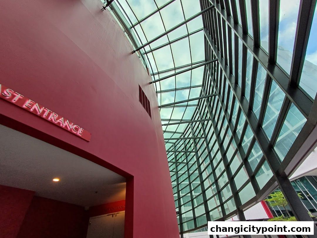 Modern architecture with a red wall and a glass ceiling at UE BizHub East.