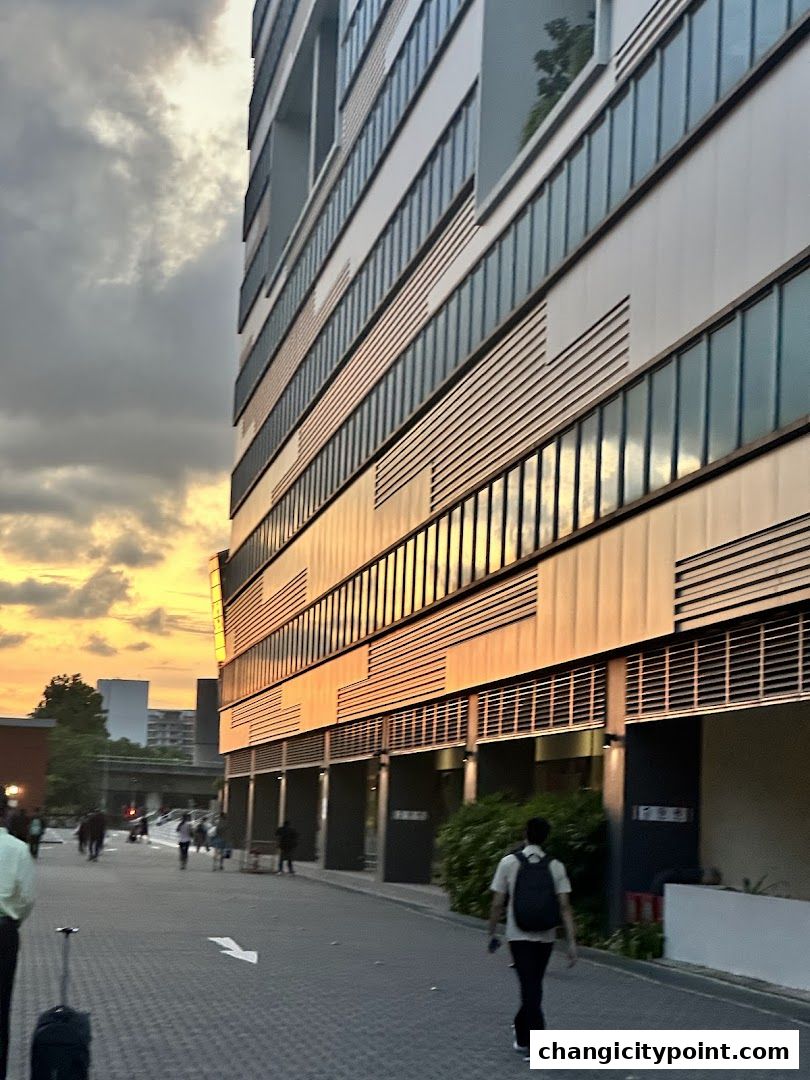 Exterior of a modern building with glass windows reflecting the sunset.