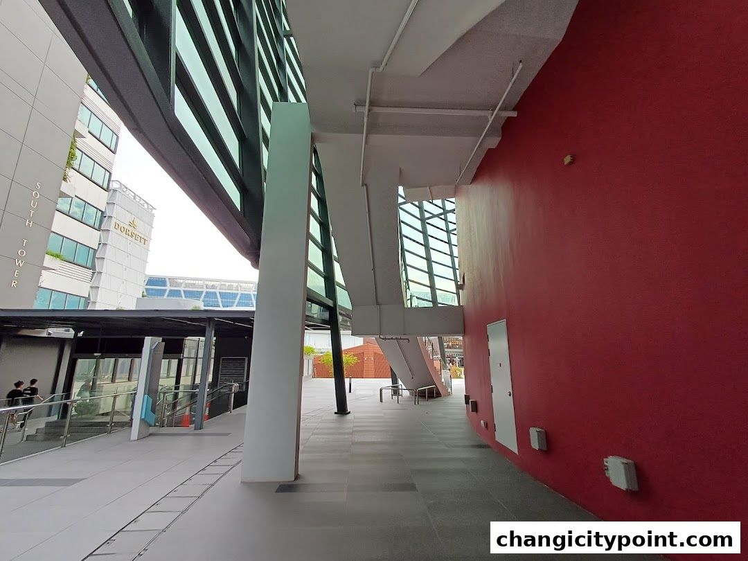 Exterior view of UE BizHub East with modern architecture and red wall.