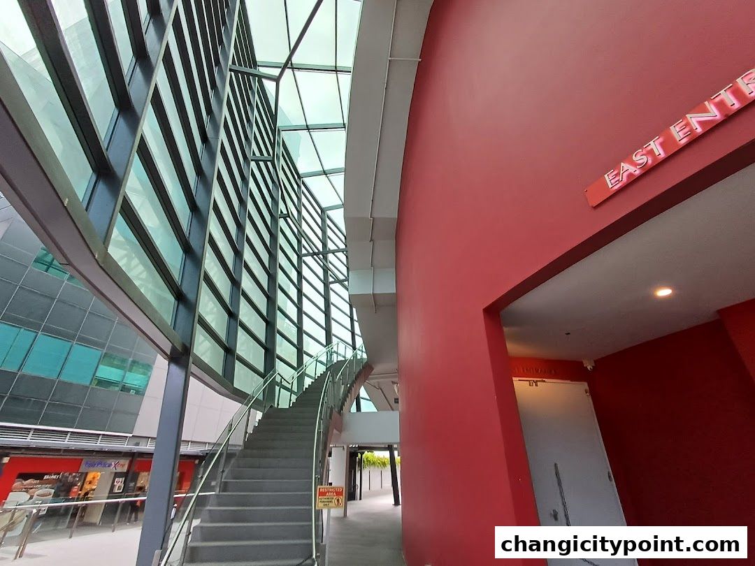 Modern architectural interior with a grand staircase and glass facade.