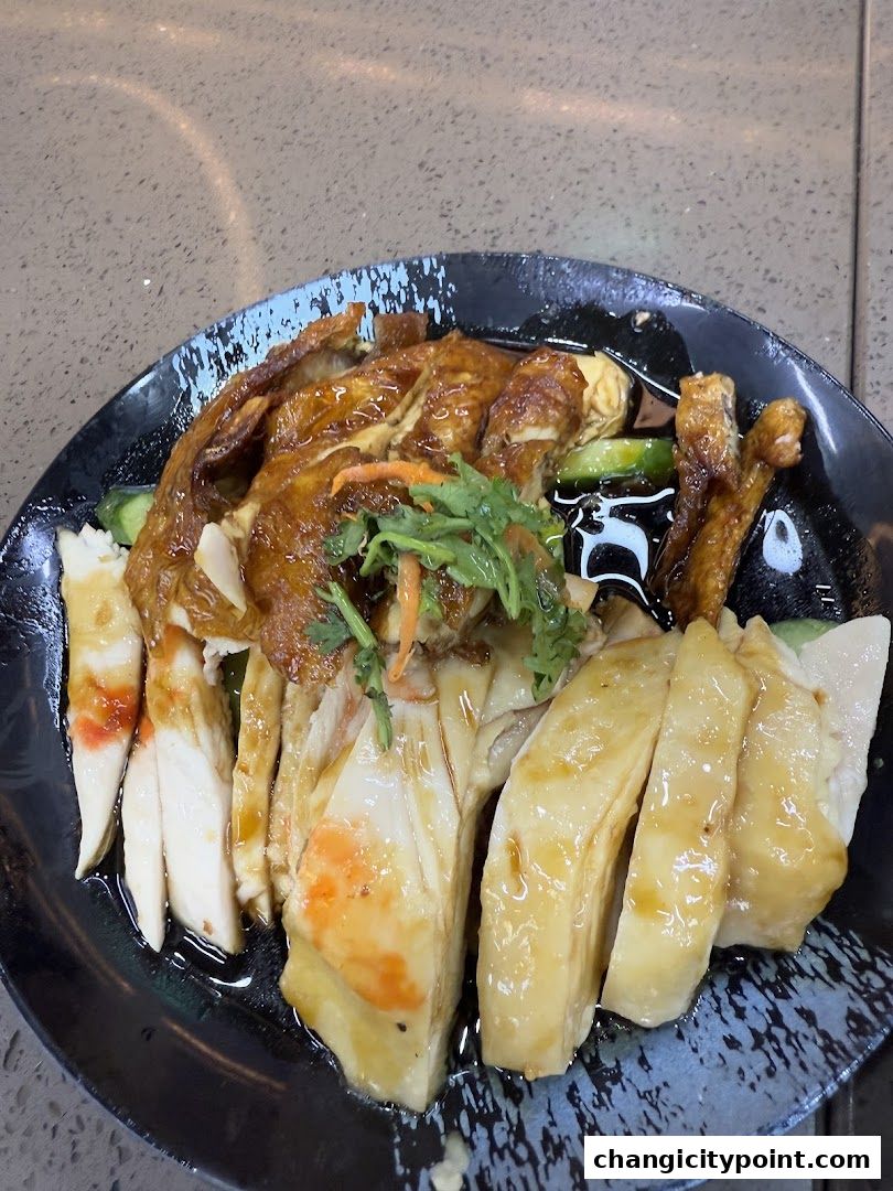 A plate of delicious chicken rice with sliced chicken and garnishes.