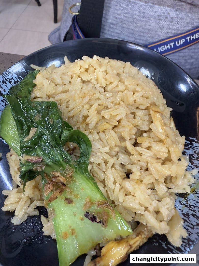 A close-up of a plate of fragrant rice with bok choy and meat.