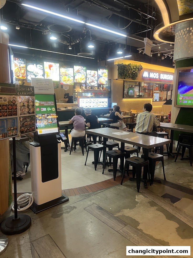Interior of Uncle Johns Makan Place food stall with menu displays and seating area.