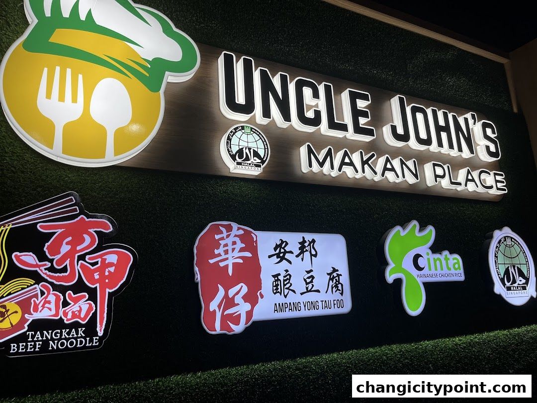 A brightly lit sign for Uncle John's Makan Place, showcasing various food offerings.
