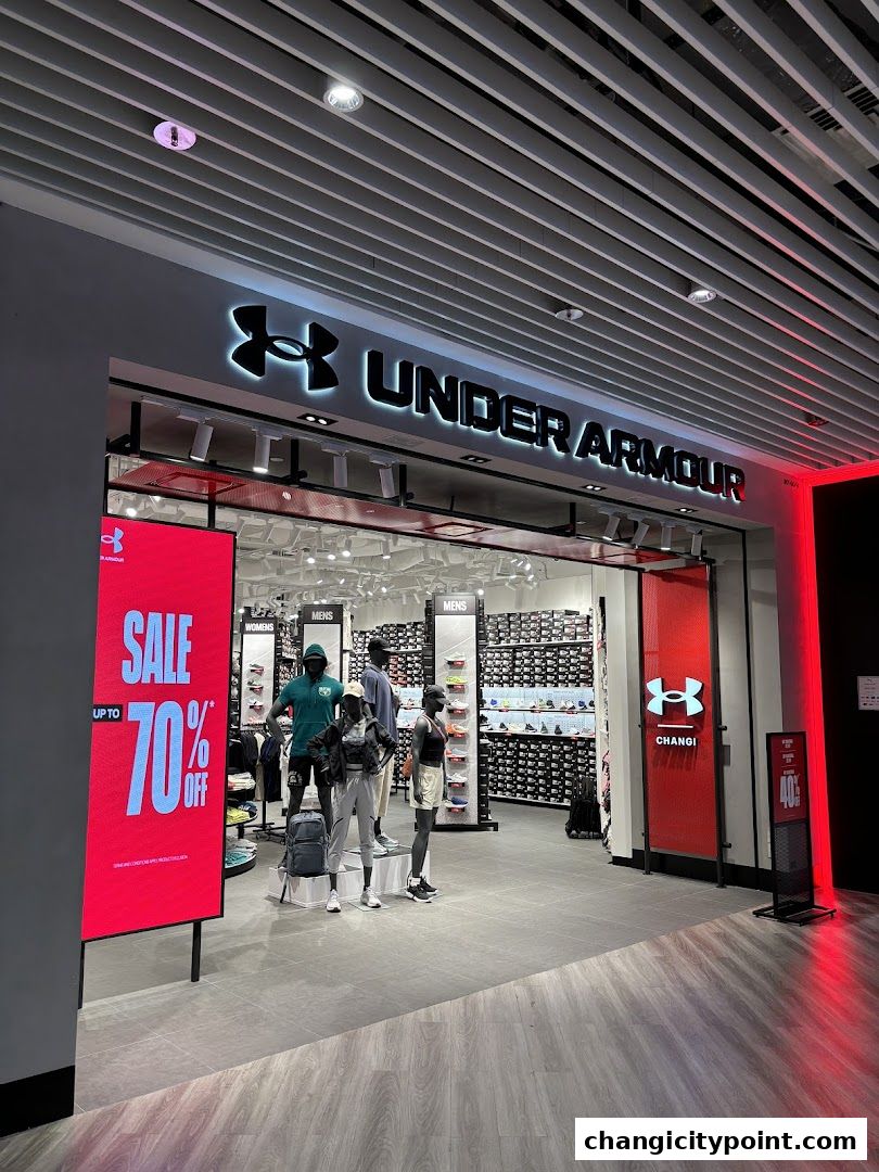 Under Armour shop front with mannequins, sale display, and shelves of shoes.