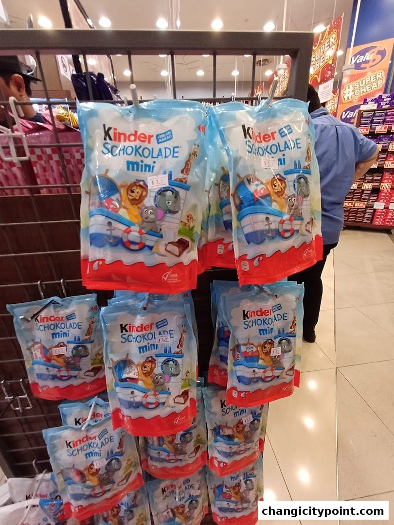 Packs of Kinder Chocolate Mini are displayed on shelves in a retail store.