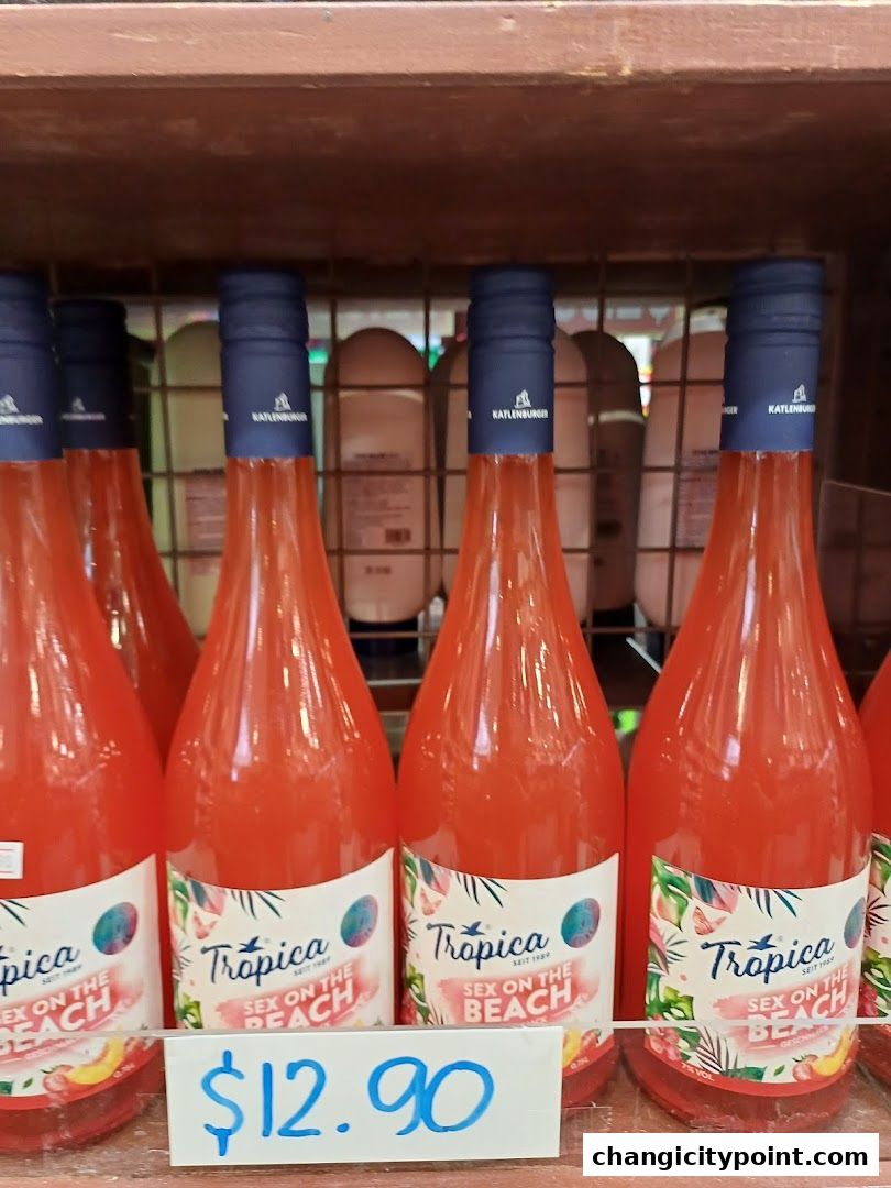 Bottles of Tropica 'Sex on the Beach' drink priced at $12.90 are displayed on a shelf.