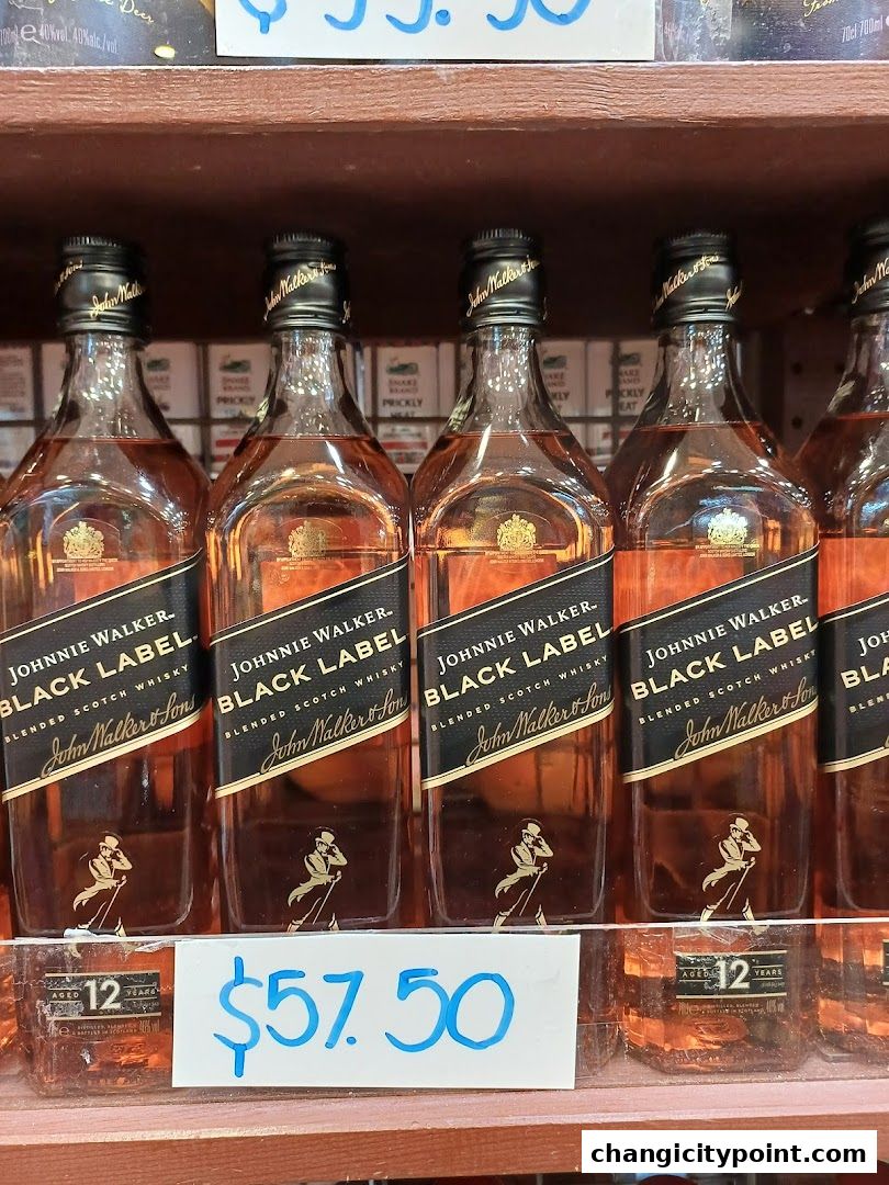 Several bottles of Johnnie Walker Black Label Scotch Whisky are displayed on a shelf with a price tag.