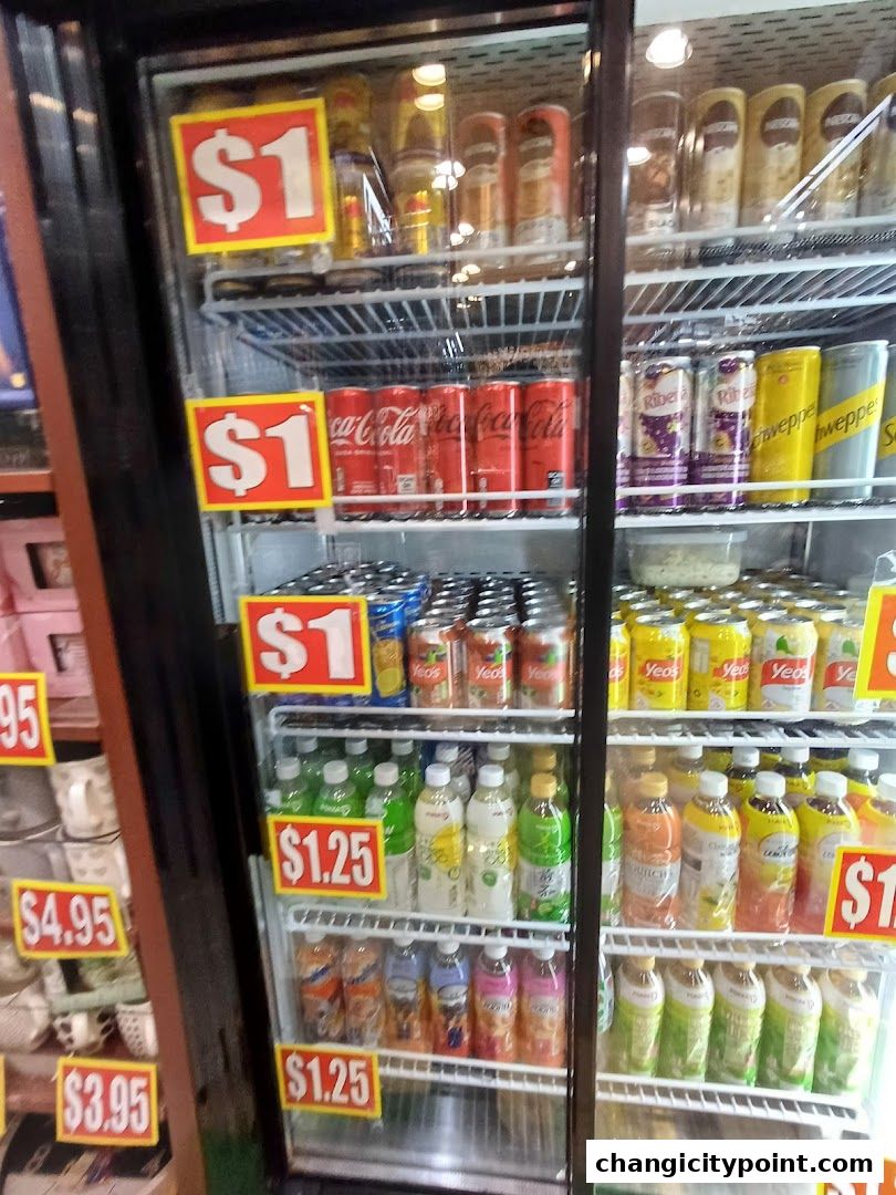 A refrigerated display case filled with various canned and bottled beverages, many with price tags.
