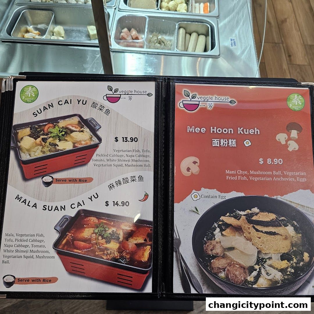 A menu from Veggie House showcasing vegetarian dishes like Suan Cai Yu and Mee Hoon Kueh.