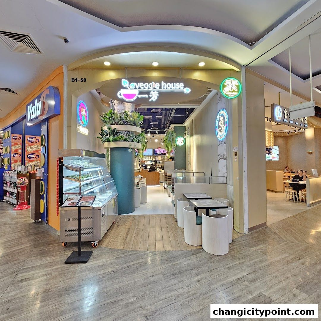 The exterior of Veggie House, a modern vegetarian restaurant with indoor seating and a display case.