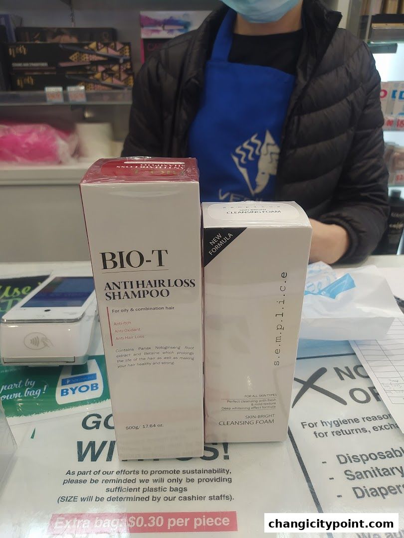 Two beauty products, shampoo and cleansing foam, are displayed at a counter.