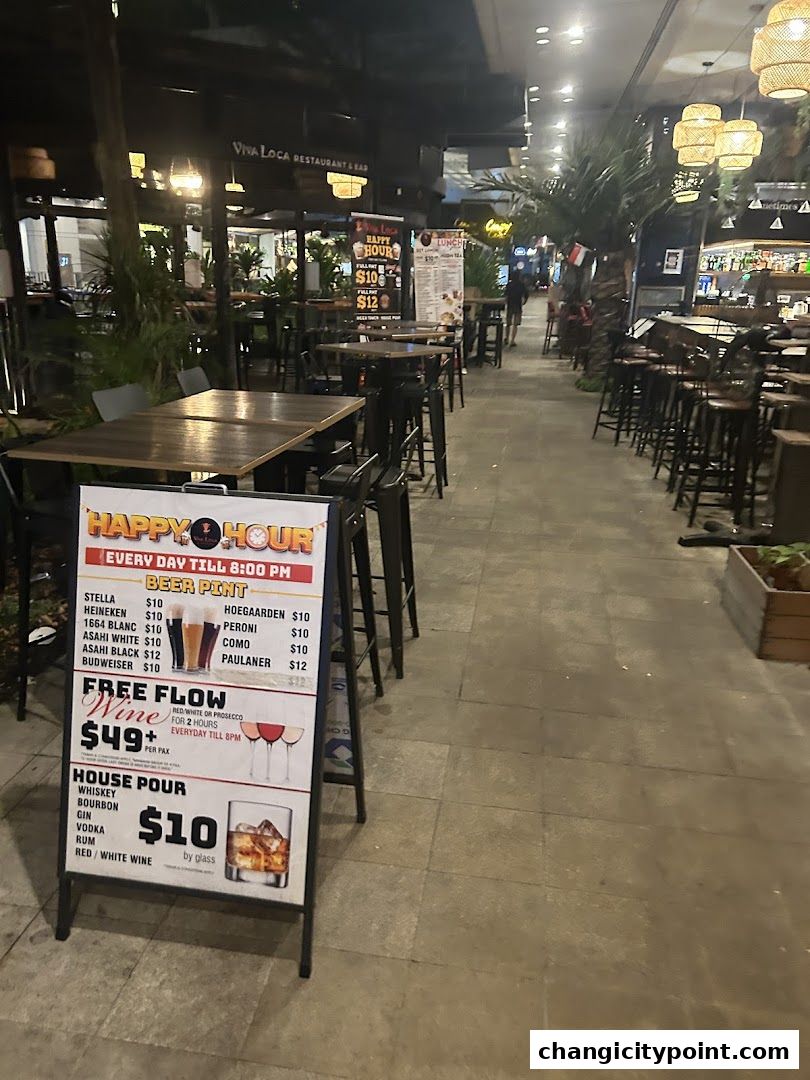 A sign advertising happy hour deals for beer, wine, and house pour drinks at Viva Loca.