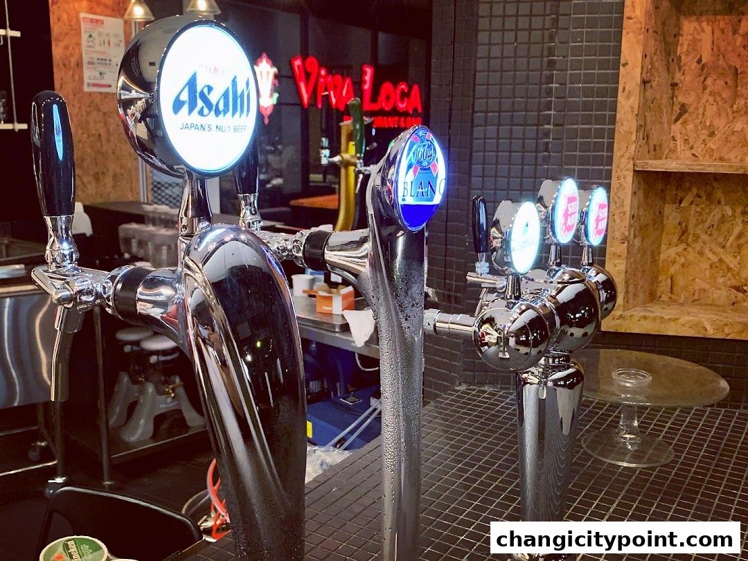 Close-up of beer taps at Viva Loca Changi, featuring Asahi and other brands.
