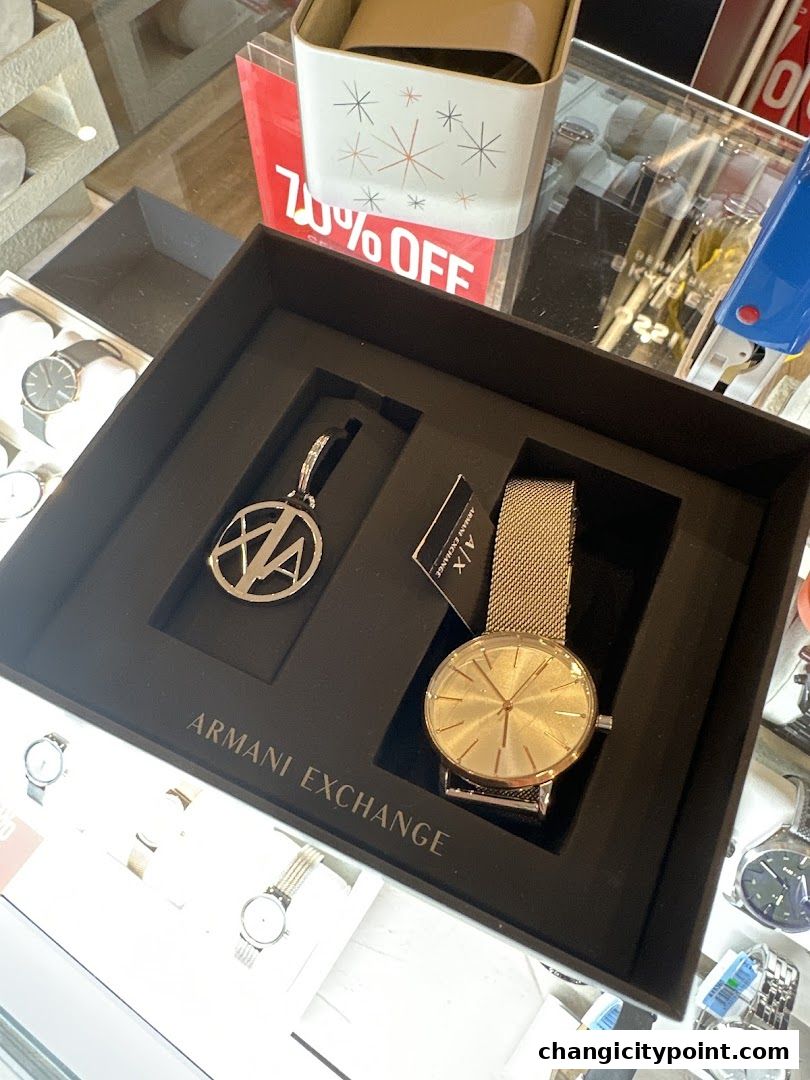 An Armani Exchange watch and keychain gift set displayed in a black box.