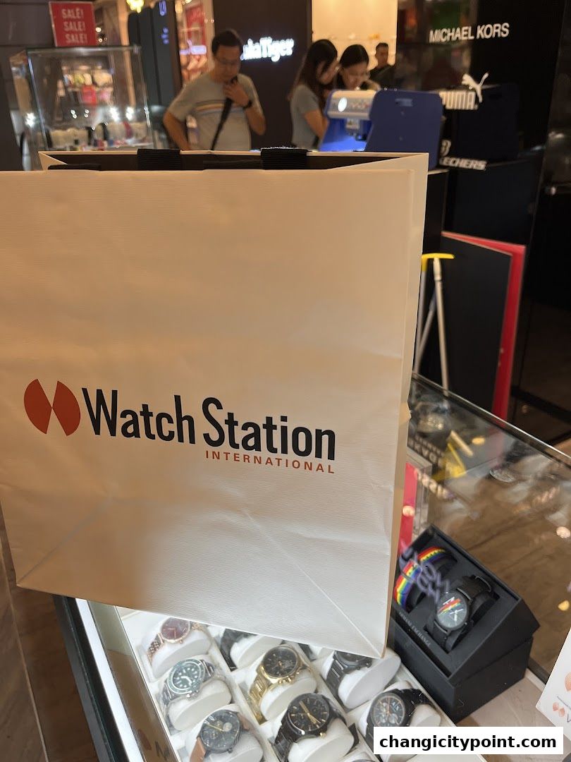 A shopping bag with 'Watch Station International' logo and display of watches.