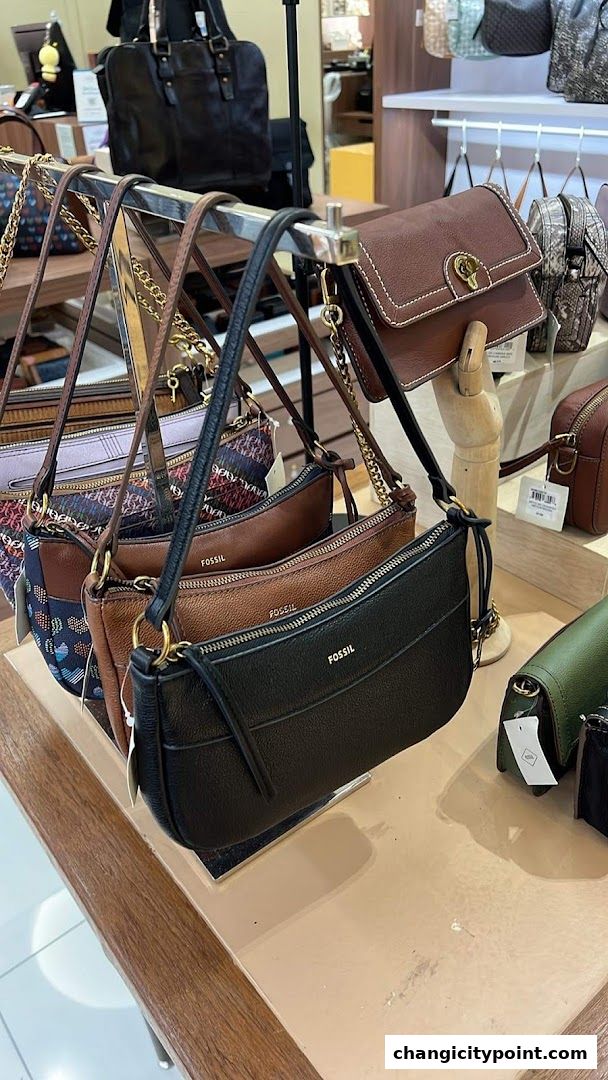 A display of Fossil handbags in various colors and styles.