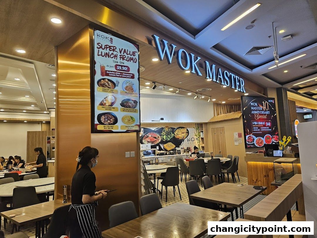Interior of Wok Master restaurant with a digital menu board and dining tables.