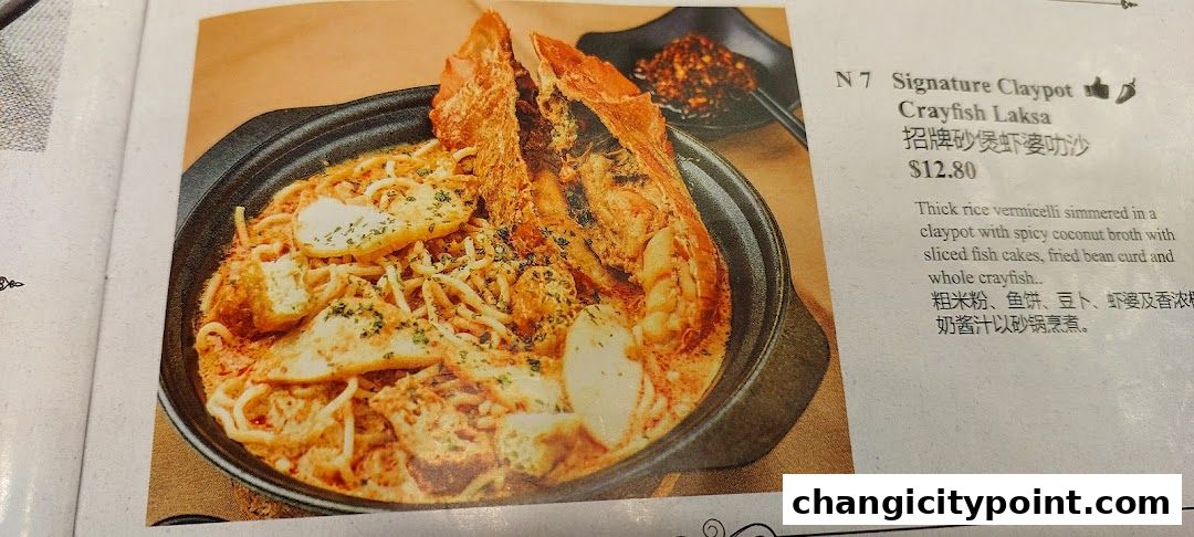 A close-up of a Signature Claypot Crayfish Laksa dish with its description and price.