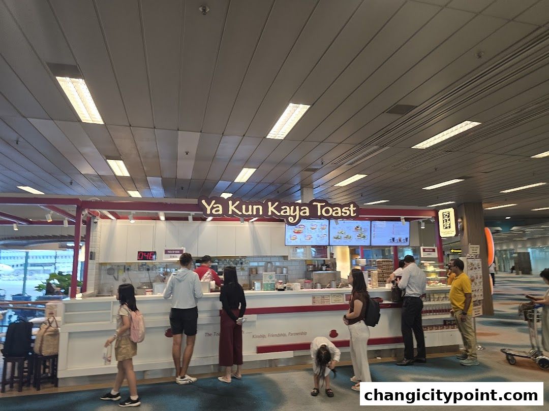 Customers queue at Ya Kun Kaya Toast, a popular Singaporean eatery, in a bright, modern setting.