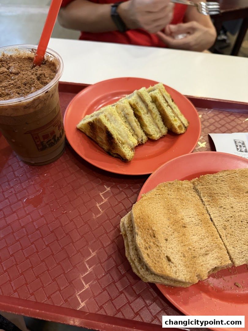 A tray with a drink and two plates of toast and sandwiches.